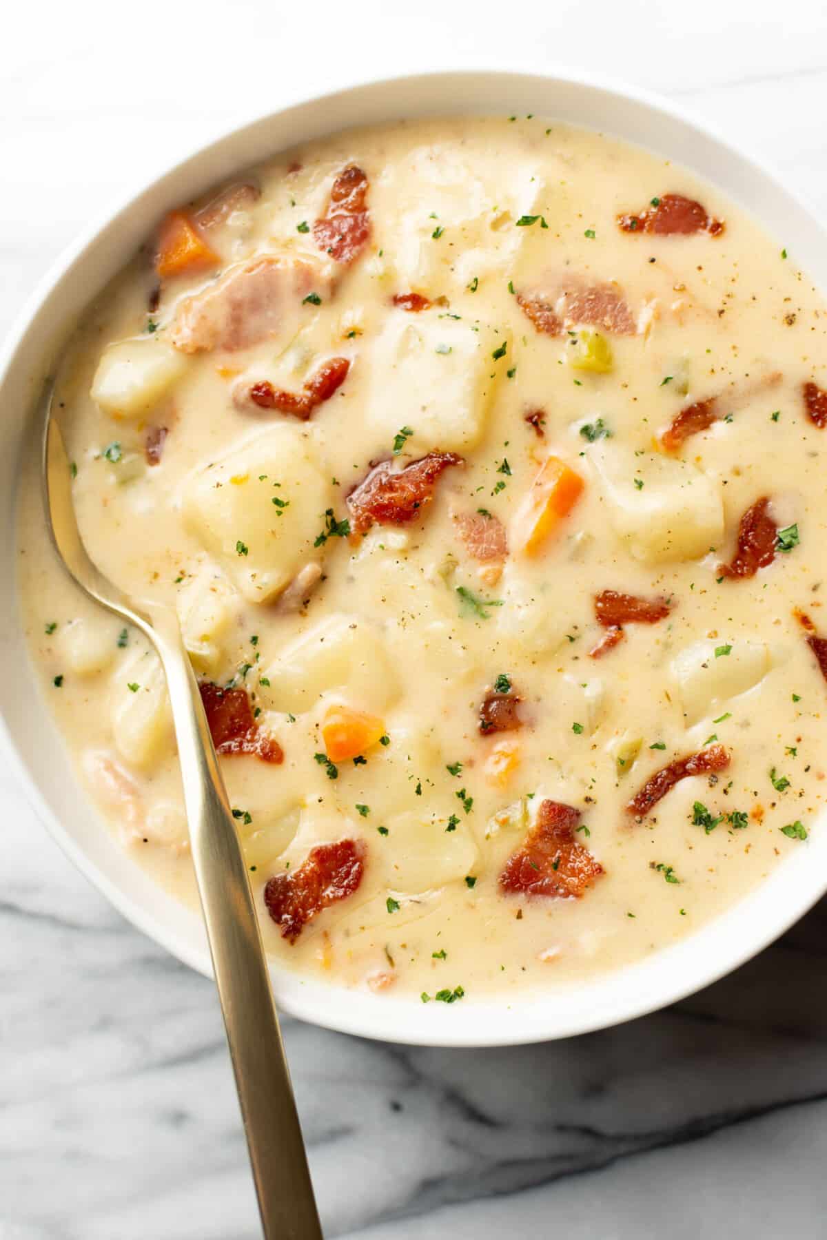 a bowl of bacon potato soup with a spoon