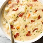 a bowl of bacon potato soup with a spoon