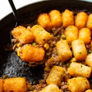 a skillet with tater tot shepherd's pie and a serving spoon