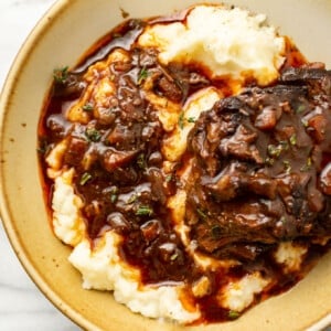 a bowl with red wine braised short ribs over mashed potatoes