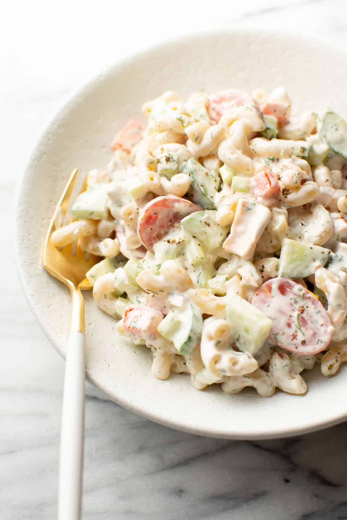 a bowl of creamy tuna pasta salad with a fork