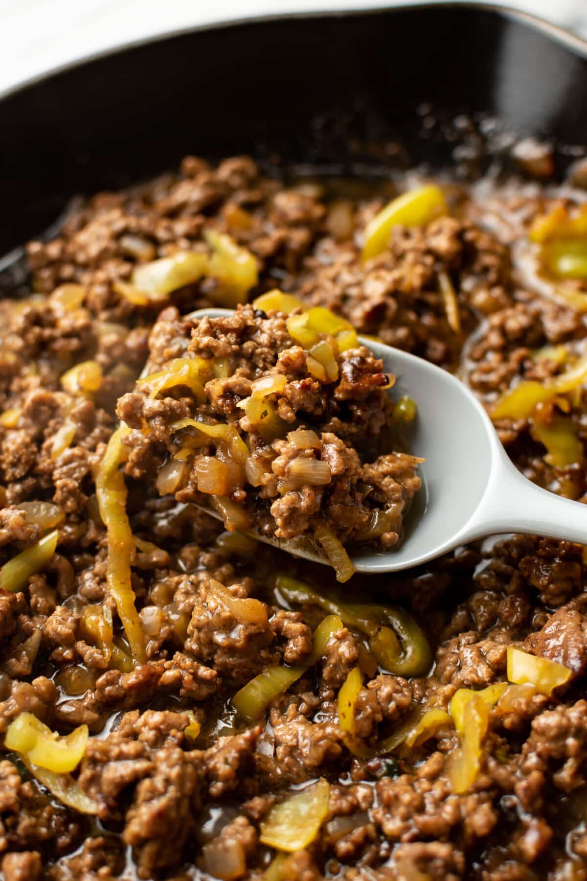 a skillet with mississippi ground beef and a spoon