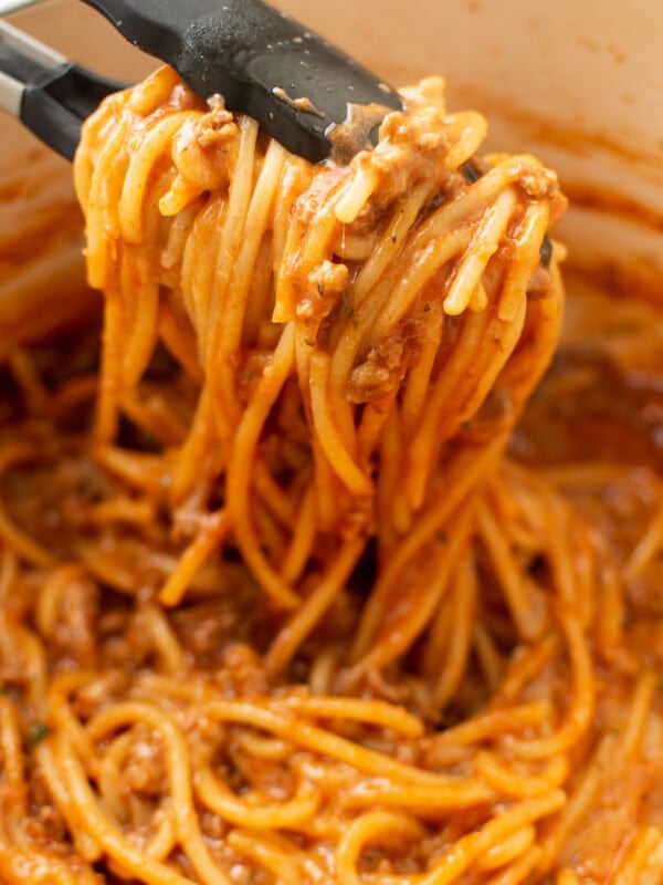 closeup of one pot spaghetti with kitchen tongs