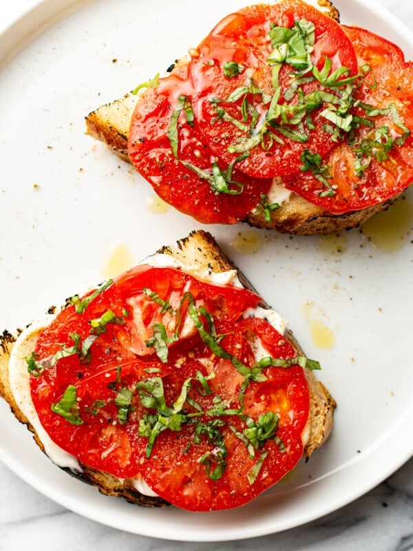 two summer tomato sandwiches on a plate