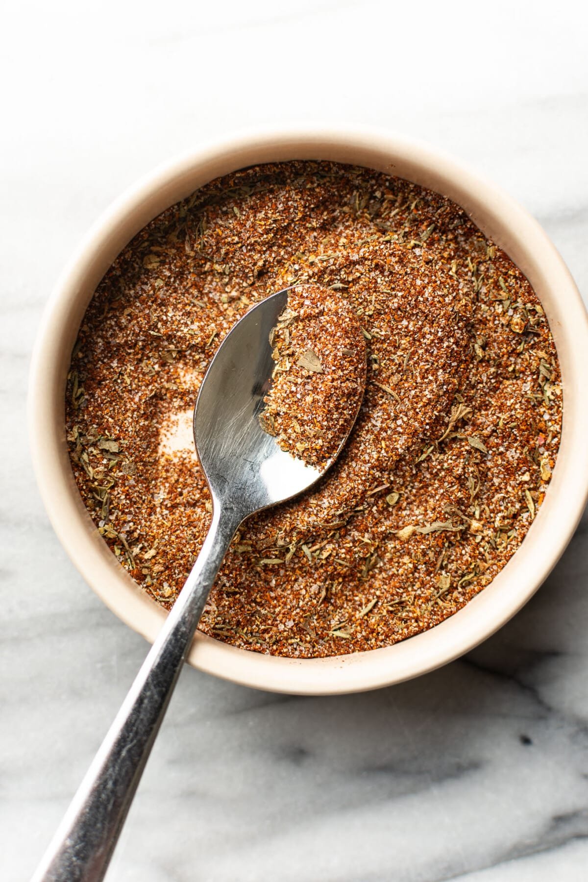 a bowl with homemade blackened seasoning and a spoon