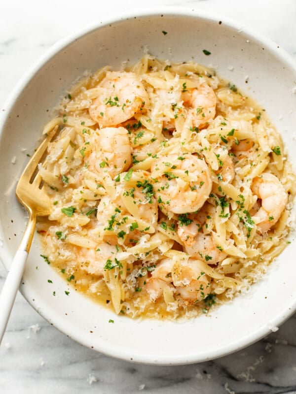 a bowl of shrimp scampi orzo with a fork