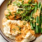 a plate with baked tomato basil chicken, green beans, and mashed potatoes