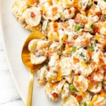 a plate with bacon ranch potato salad and a serving spoon