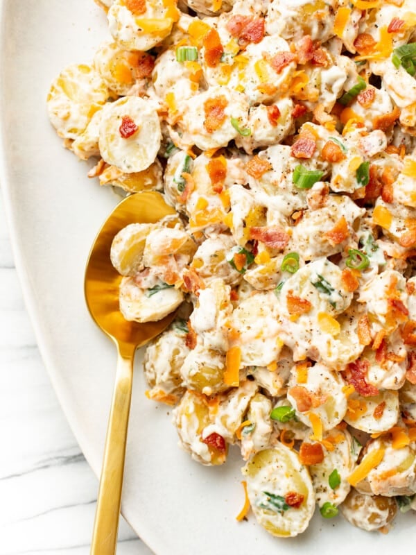 a plate with bacon ranch potato salad and a serving spoon