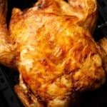 a whole roast chicken in an air fryer basket