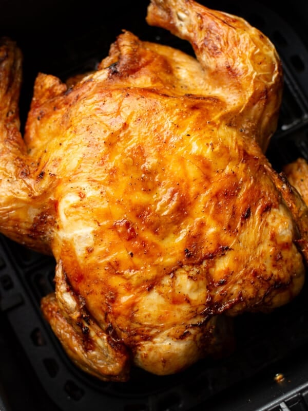 a whole roast chicken in an air fryer basket