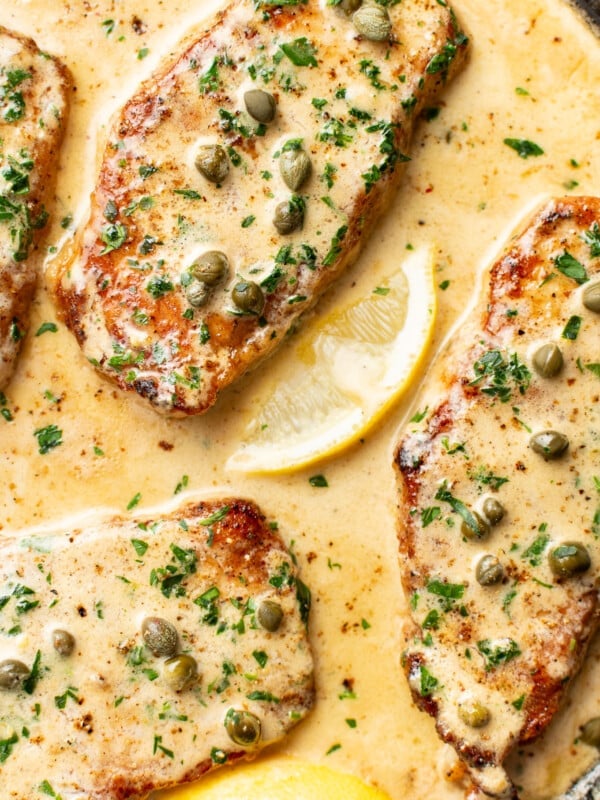 a skillet with pork chops piccata