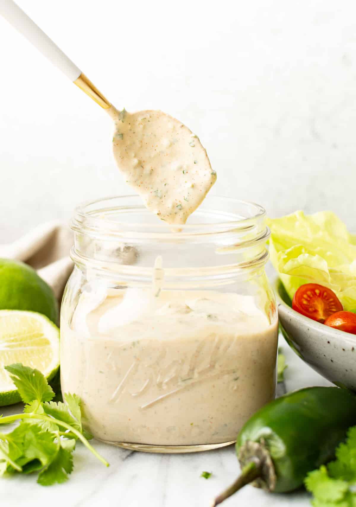 a jar with jalapeno ranch dressing and a spoon
