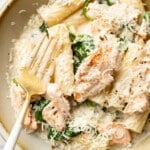 a bowl of lemon spinach salmon pasta with a fork