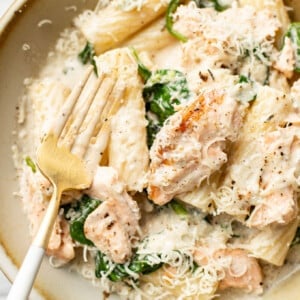 a bowl of lemon spinach salmon pasta with a fork