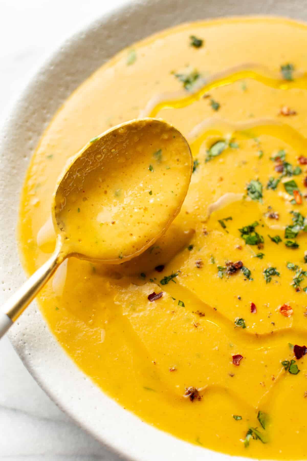 a bowl of spicy lentil soup with a spoon