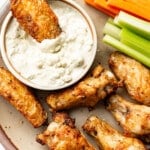 buffalo wings on a plate with homemade blue cheese dressing, carrots, and celery