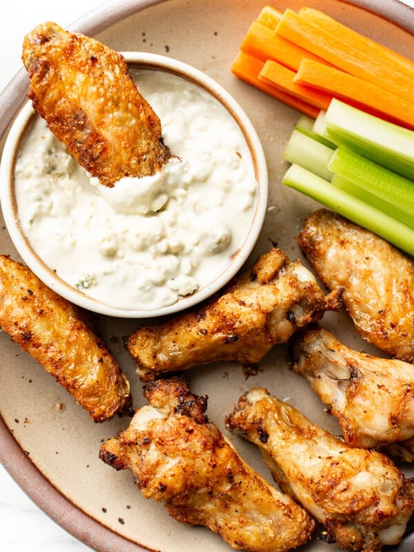 buffalo wings on a plate with homemade blue cheese dressing, carrots, and celery