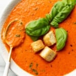 a bowl of roasted red pepper soup with a spoon