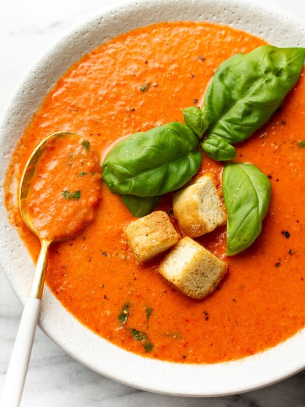 a bowl of roasted red pepper soup with a spoon