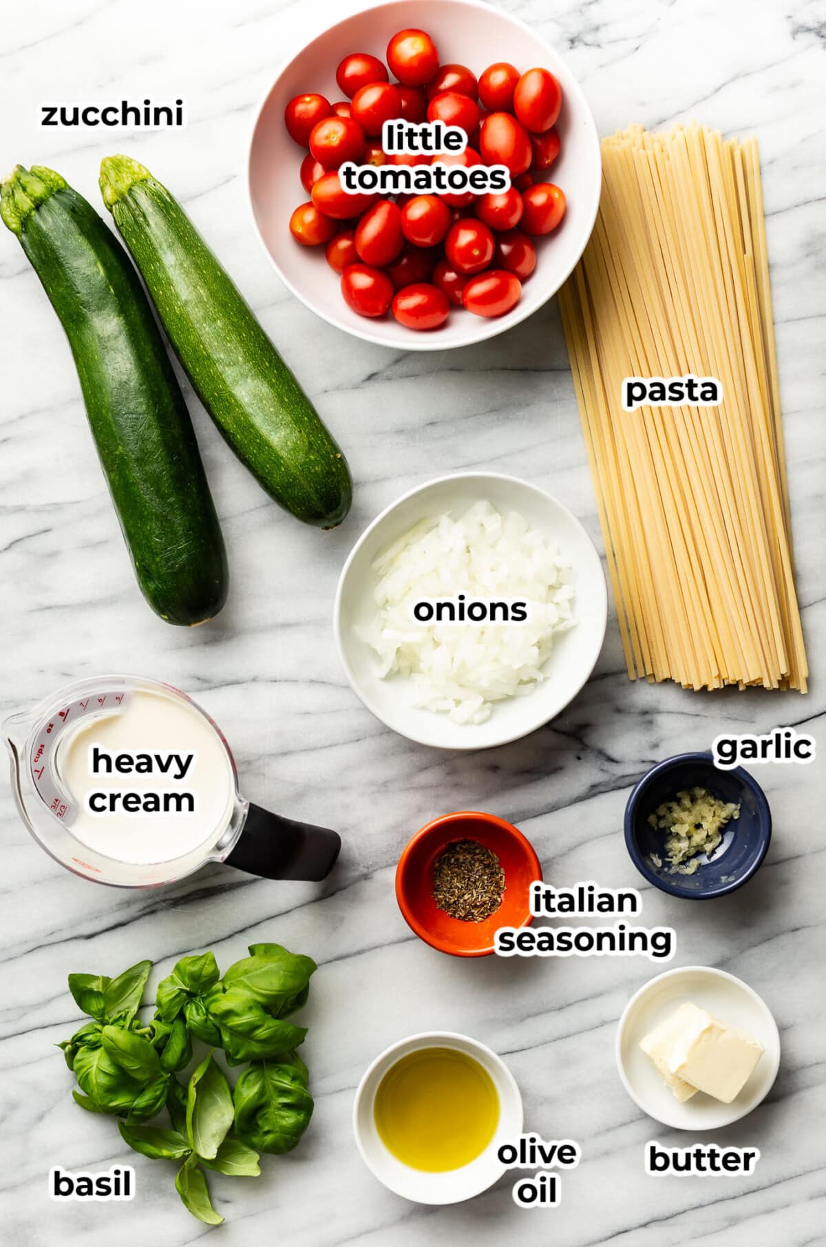 ingredients for zucchini tomato pasta in prep bowls