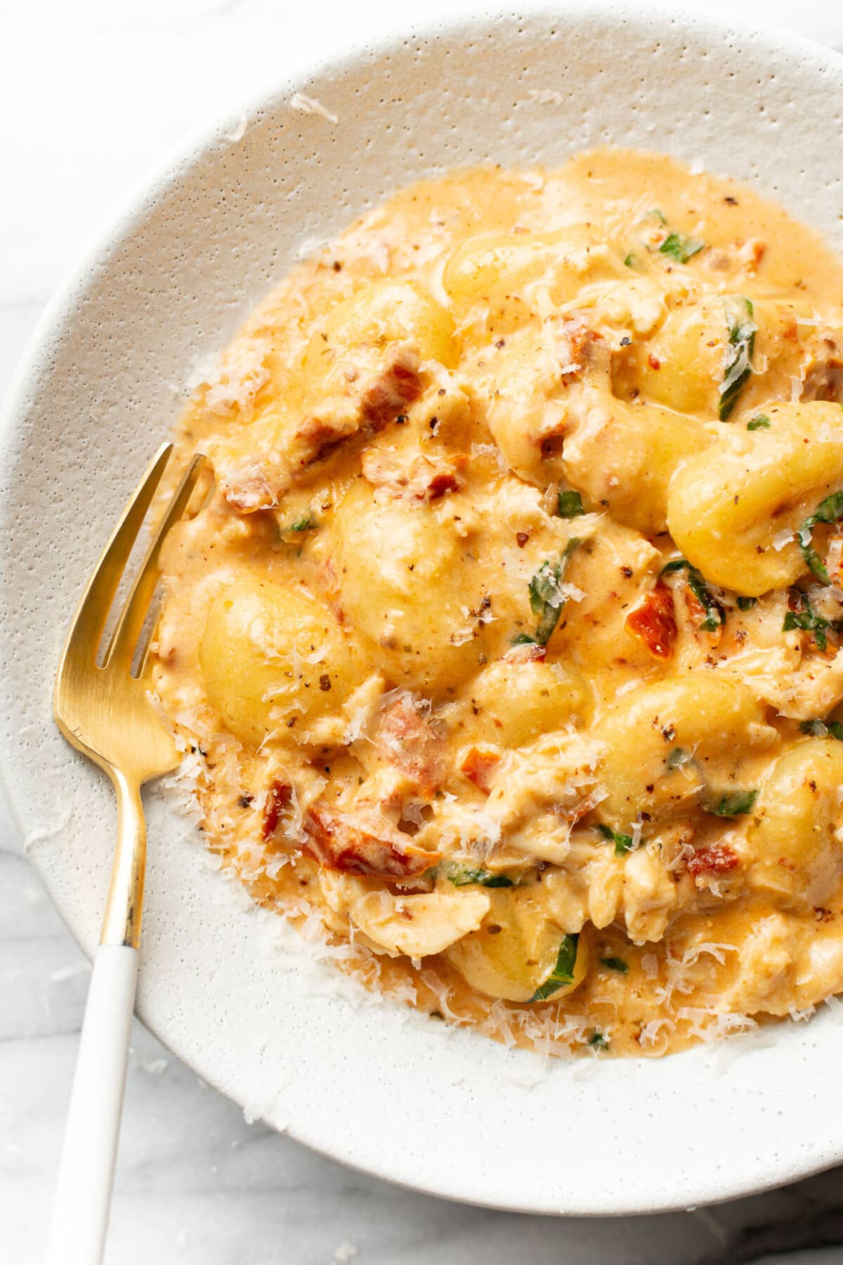 a bowl of marry me chicken gnocchi with a fork