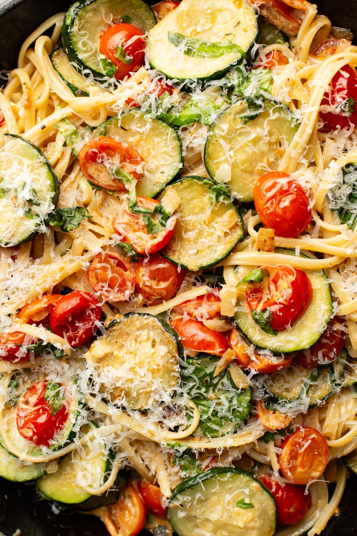 closeup of a skillet with zucchini and tomato pasta